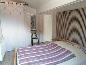 a bedroom with a bed with a striped blanket on it at LE CHAMOIS DORT in Die +10 photos