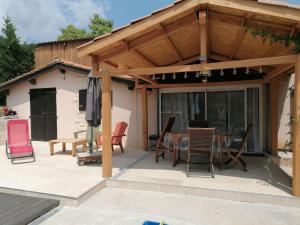 a covered patio with chairs and a table at LE CHAMOIS DORT in Die