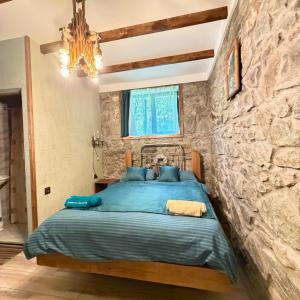 a bedroom with a bed in a stone wall at HALI Guest Hause in Dilijan