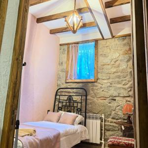 a bedroom with a bed and a stone wall at HALI Guest Hause in Dilijan