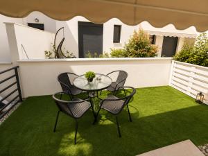 a patio with a table and chairs on the grass at Crystal 1 Apartment Ofrinio in Ofrínion