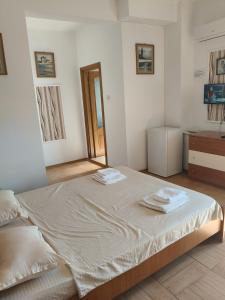 a bedroom with a large bed with two towels on it at Vila Cristal Costinesti in Costinesti