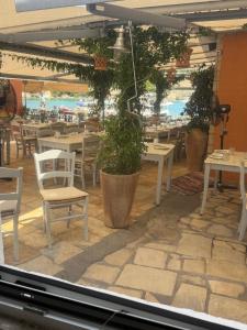 Blick auf ein Restaurant mit Tischen und Stühlen in der Unterkunft Tolos Budget Rooms Loggos in Longós
