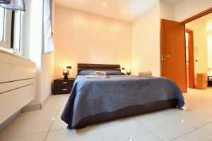 a bedroom with a bed with a blue bedspread at La Casa nel Borgo, a 20 minuti da Roma, relax e comfort con tutte le dotazioni, WiFi free in Monterotondo +17 photos