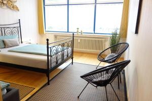 a bedroom with a bed and two chairs in front of a window at Ferienwohnung Solling Niedersachsen in Uslar