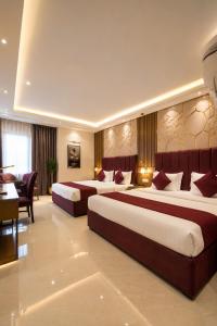a hotel room with two beds and a desk at Hotel Perfectionist- Free Airport Pickup in New Delhi