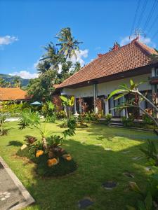 a house with a lawn in front of it at Mandala Home Villa in Culik