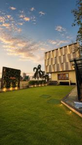 a building with a grassy field in front of a building at HOTEL AMORA - Rajnandgaon in Rāj Nāndgaon