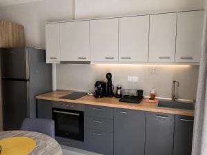 a kitchen with white cabinets and a counter top at Crystal 1 Apartment Ofrinio in Ofrínion +6 photos