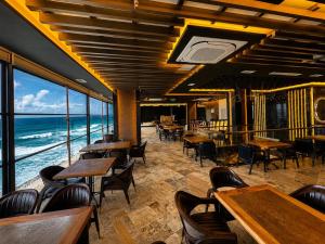 a restaurant with tables and chairs and the ocean at The New Jai Son in Kobuleti
