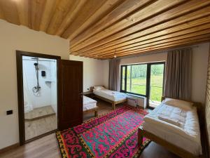 a room with a bedroom with a shower and a rug at Kordon guest house in Tar-Suu