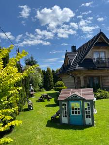 a house with a toy dog house in the yard at Szałas Kosówka in Witów