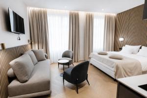 ein Hotelzimmer mit einem Bett und einer Couch in der Unterkunft Hotel Flaneur in Belgrad