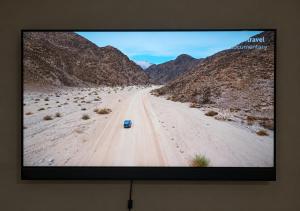 a television screen showing a dirt road in the desert at Suider Ozias Self Catering in Windhoek