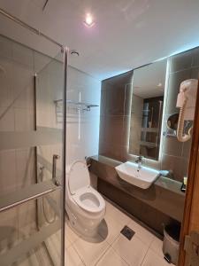 a bathroom with a toilet and a sink at Al Madina Golden Hotel in Medina +5 photos
