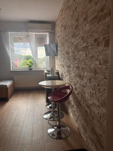 a room with a table and a brick wall at Noclegi i Restauracja Gracja in Bełchatów