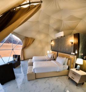 a bedroom in a tent with two beds and a couch at Wadi Rum Luxury Hamad & Jeep Tours in Wadi Rum