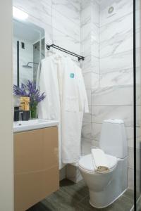 a white bathroom with a toilet and a sink at Silence hotel in Cholpon-Ata +146 photos