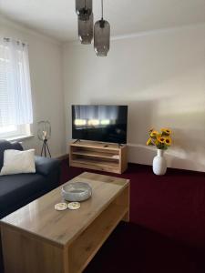 a living room with a tv and a coffee table at Apartments Zur Eiche in Großräschen