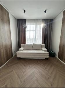 a living room with a couch in front of a window at Franko Aparts in Uzhhorod