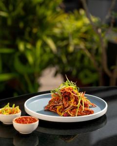 a plate of food sitting on a table with sauce at Hotel Park Elanza Chennai in Chennai +55 photos