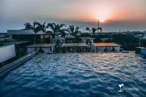 a swimming pool with the sunset in the background at Hotel Park Elanza Chennai in Chennai
