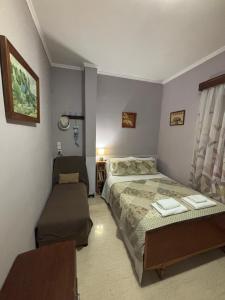 a bedroom with a bed and a chair in it at The Village Corner in Politika