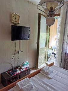 a bedroom with a bed and a tv and a window at Apartman Ex-Yu in Španjola
