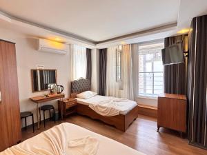 a hotel room with a bed and a desk and a bedroom at Hisar Çeşme Hotel in Istanbul