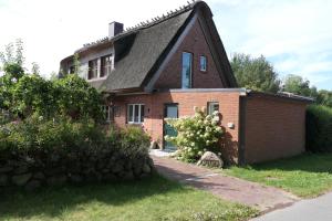 ein Backsteinhaus mit Mansarddach in der Unterkunft Lüttdeel in Gelting