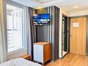 a bedroom with a tv on the wall and a bed at Hisar Çeşme Hotel in Istanbul