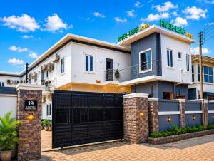 a white house with a black garage at Riverleaf Hotels and Suites in Asaba