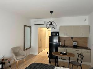 a kitchen and living room with a table and chairs at Soliq Stay App in Tuzla