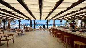 a restaurant with a bar with a view of the beach at Naxia Gaia Suites in Agia Anna Naxos