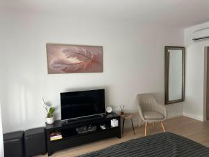 a living room with a television and a chair at Soliq Stay App in Tuzla