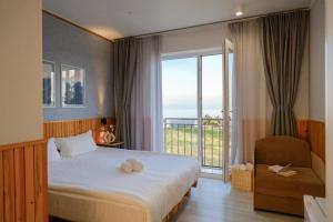 a bedroom with a bed and a window with a balcony at Silence hotel in Cholpon-Ata