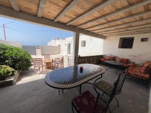 a patio with a table and chairs and a couch at Maison chez Hassan in Wassane
