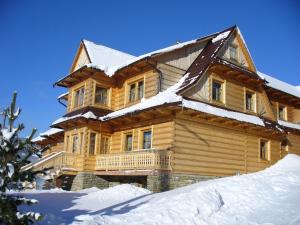 a large wooden house with snow on it at Drevenica Gabriel in Ždiar