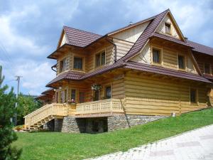 a large wooden house with a balcony on a hill at Drevenica Gabriel in Ždiar