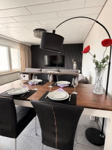 a dining room table with chairs and a vase with red roses at Apartment Prinz Luis in Owingen +22 photos
