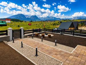 a farm with a fence and a field with mountains at Mountain Whisper in Žabljak