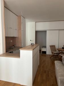 a kitchen with white cabinets and a table at Apartment MareMare Budva in Rafailovici