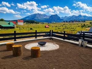 a fire pit in a field with mountains in the background at Mountain Whisper in Žabljak