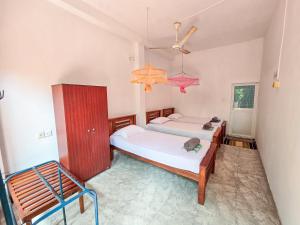 a bedroom with two beds and a chandelier at Jayaru Guest House in Polonnaruwa