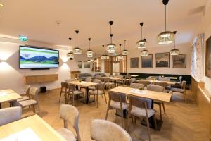 a restaurant with tables and chairs and a flat screen tv at Flackl - Wirt in Reichenau