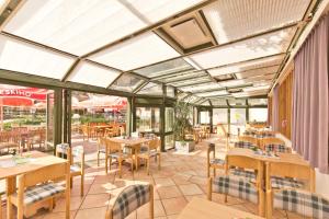 a restaurant with tables and chairs and windows at Flackl - Wirt in Reichenau