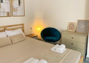a bedroom with a bed and a blue chair at Open Sky Verige Studio in Donja Jošica