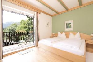a bedroom with a bed and a large window at Flackl - Wirt in Reichenau +25 photos