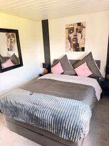 a bedroom with a large bed with pink pillows at Apartment Prinz Luis in Owingen