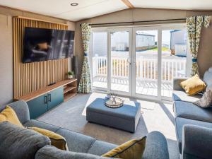 a living room with a couch and a tv at Peachy in Heysham